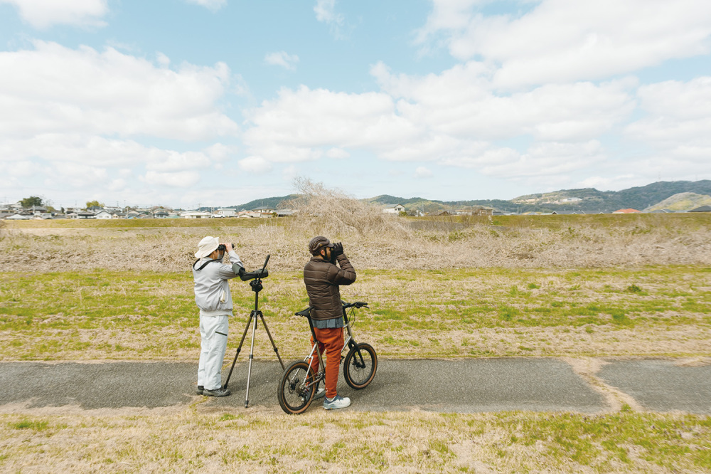 Lucas and our birding guide Taniwaki-san watch the birds flying over the Kishi River, a tribute of the Kinokawa River
