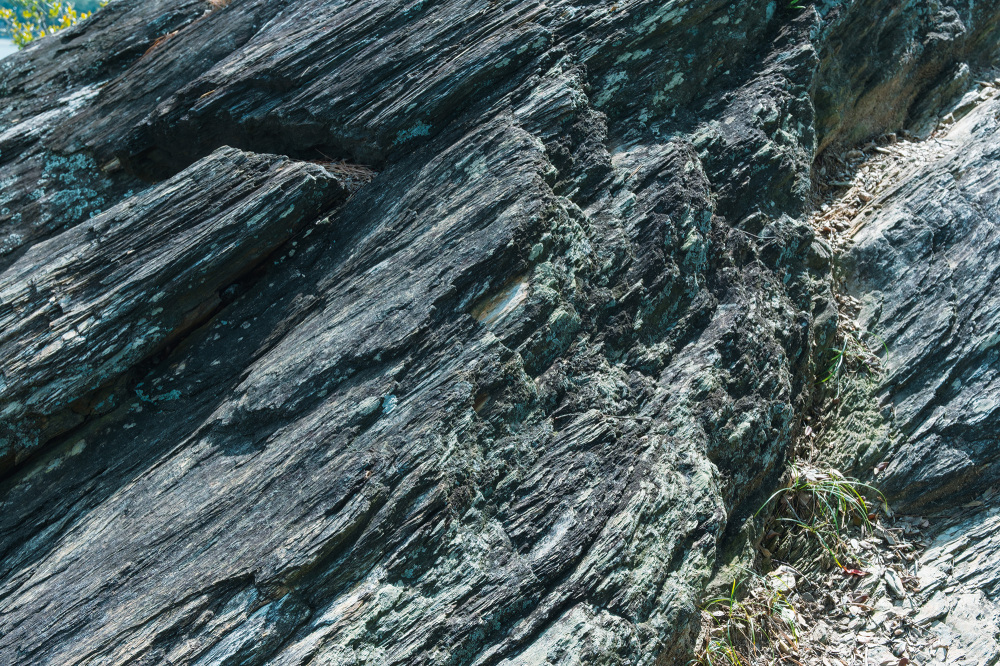 Pelitic schist found throughout the Wakanoura area. Thin, dark layers or rock overlap to create striped patterns, forming a beautiful contrast with the deep blue sea.