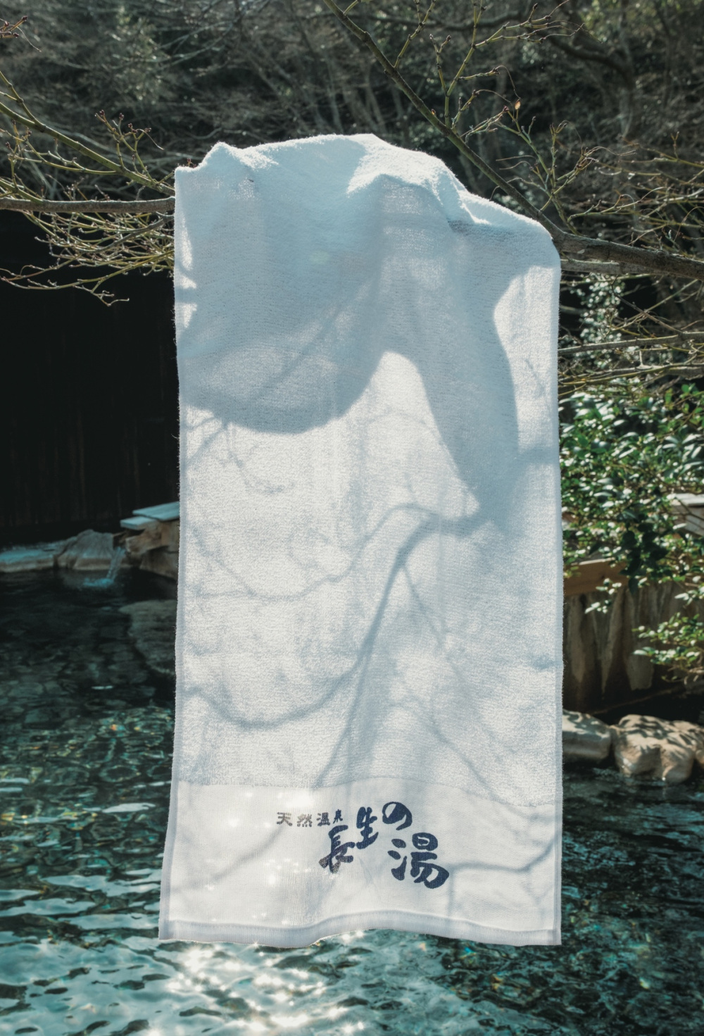 An open-air bath surrounded by cherry trees and maples.